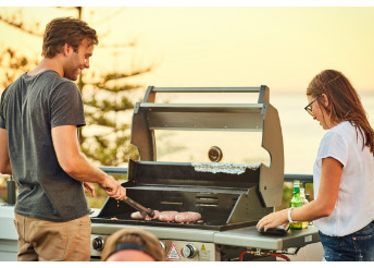 Male standing at a grill with a girl